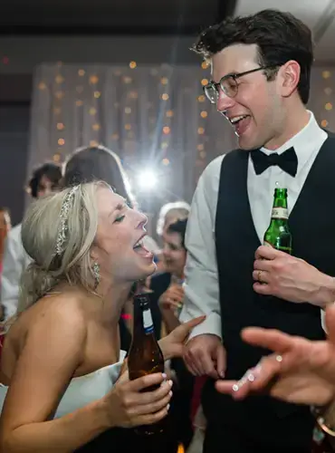Bride and groom singing and dancing on a packed dance floor at a Pittsburgh wedding reception