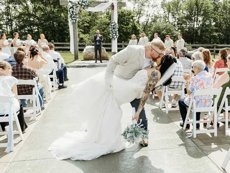 Bride and groom kissing in a dip while exiting their wedding ceremony at a Pittsburgh wedding with Soundwaves Event Group DJ services