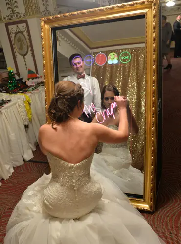Bride and groom using a Magic Mirror Photo Booth while signing the mirror at a Pittsburgh wedding