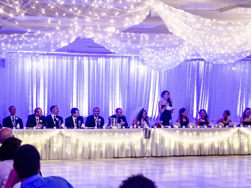 Purple uplighting illuminating pipe and drape at a wedding reception at Rostraver Fire Hall in Pennsylvania with Soundwaves Event Group