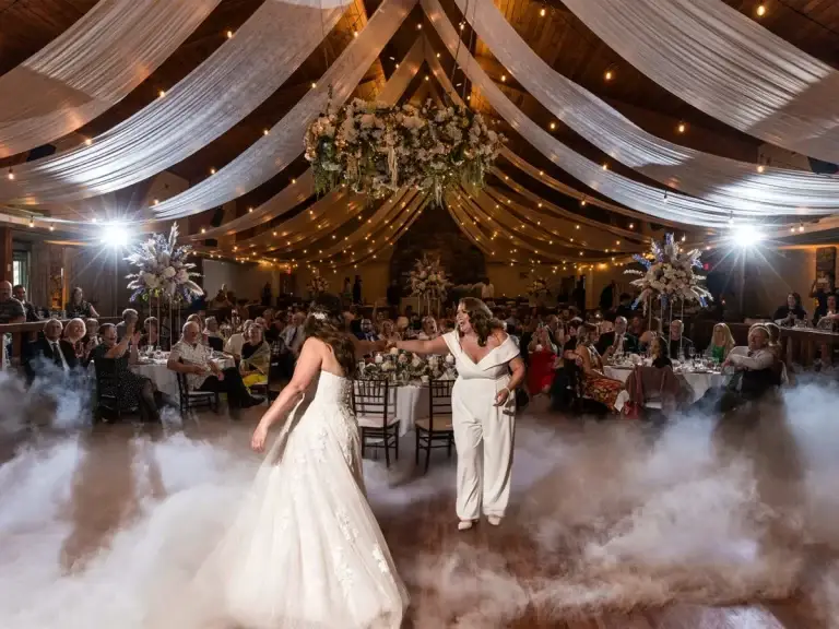 Two brides sharing their first dance with dancing on a cloud at an Oglebay wedding as guests celebrate