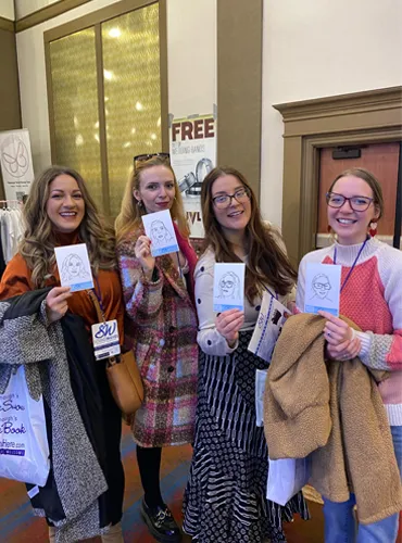 Four wedding guests holding their custom sketch portraits created by the Sketched by SWEG sketch robots at a Pittsburgh wedding
