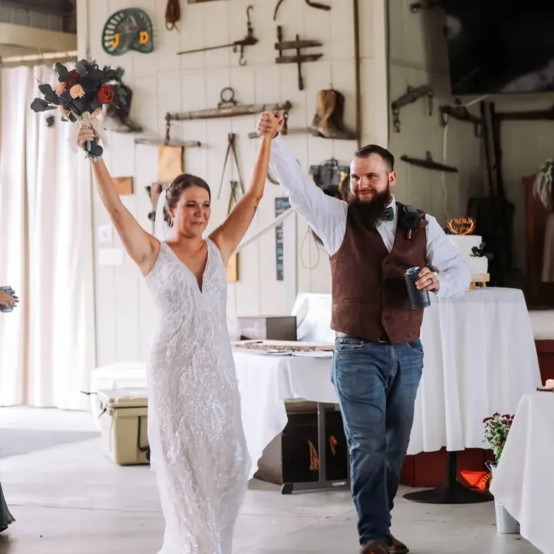 Bride and groom making their grand entrance with hands in the air at Pretzel Arena in Bruceton Mills WV
