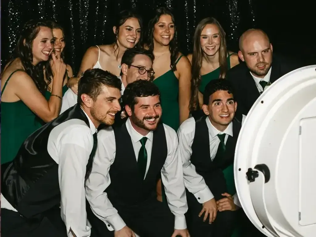 Bride, bridesmaids, groom, and groomsmen striking a pose at Pittsburgh wedding photo booth