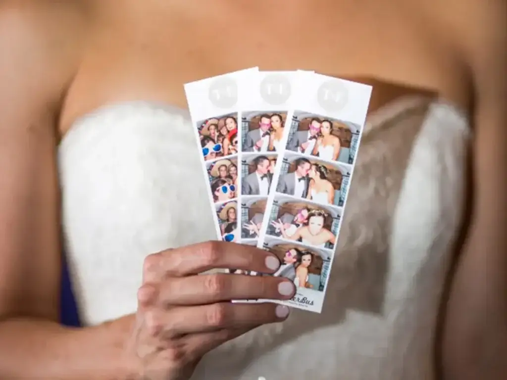 Bride holding printed photo strips at Pittsburgh wedding photo booth