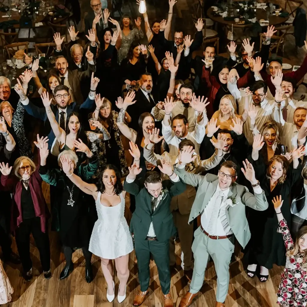 Large group of wedding guests with hands in the air on the dance floor at The Roost Event Center in Mahaffey PA