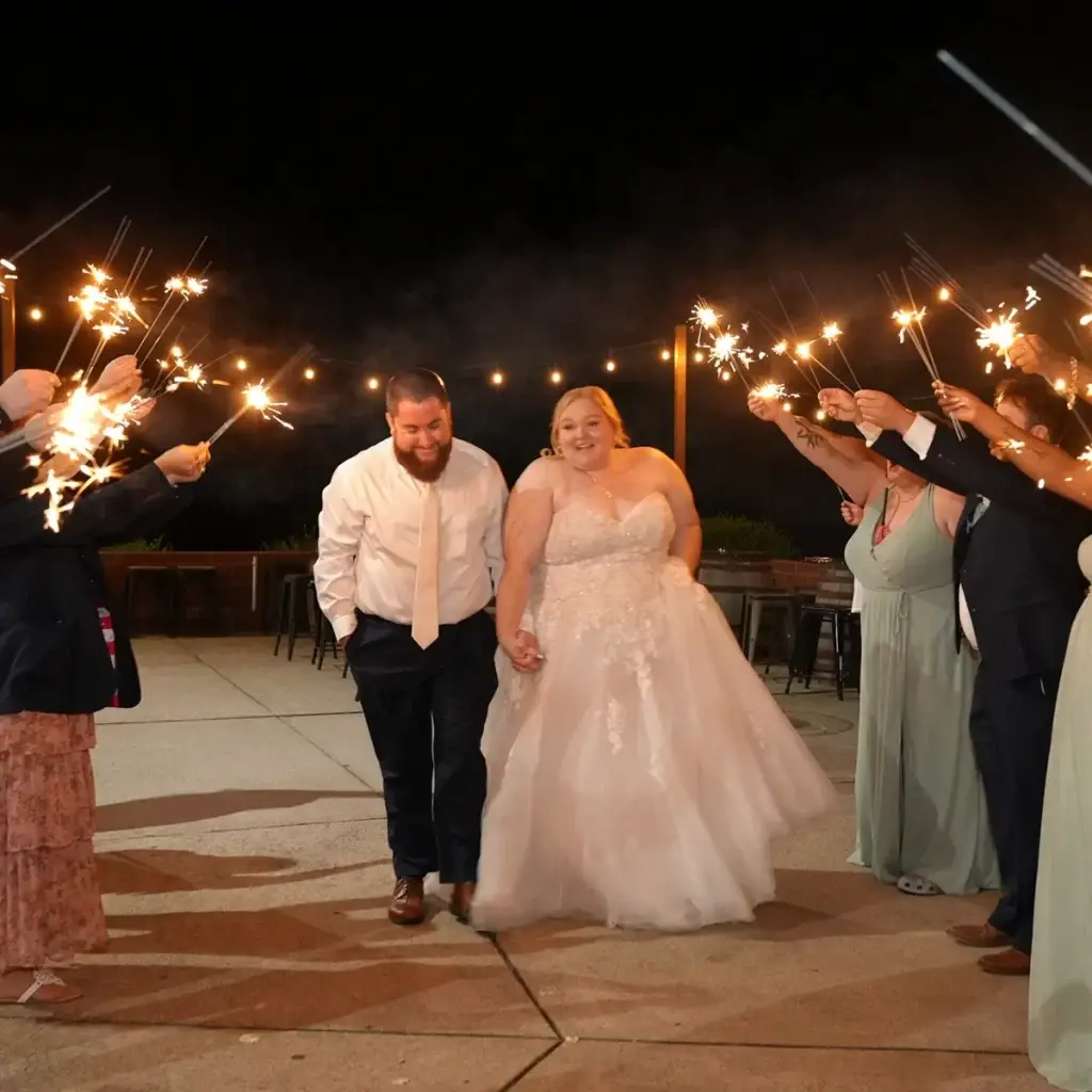 Bride and groom walking through a sparkler exit with guests at Yinzer Valley Farms in Mount Pleasant, Pennsylvania