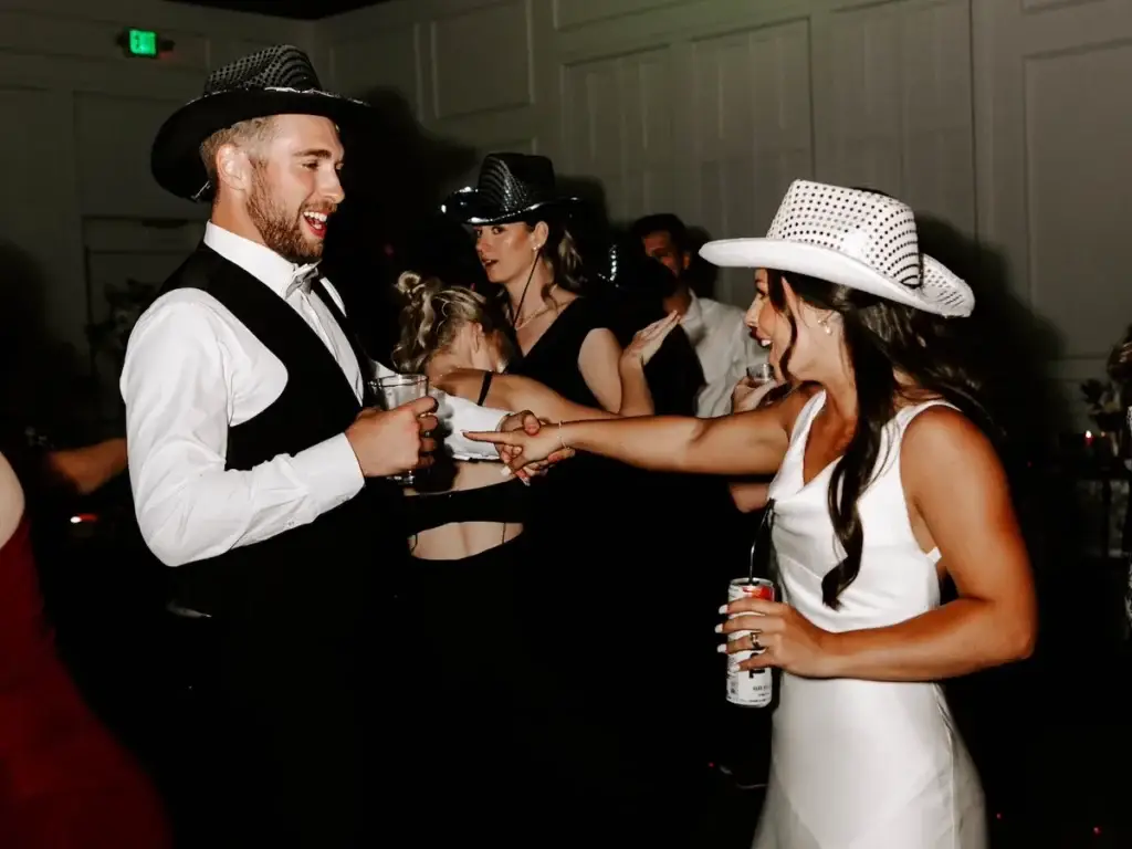 Bride and groom wearing cowboy hats dancing on a packed dance floor at their wedding reception at The Audrey in Canonsburg PA