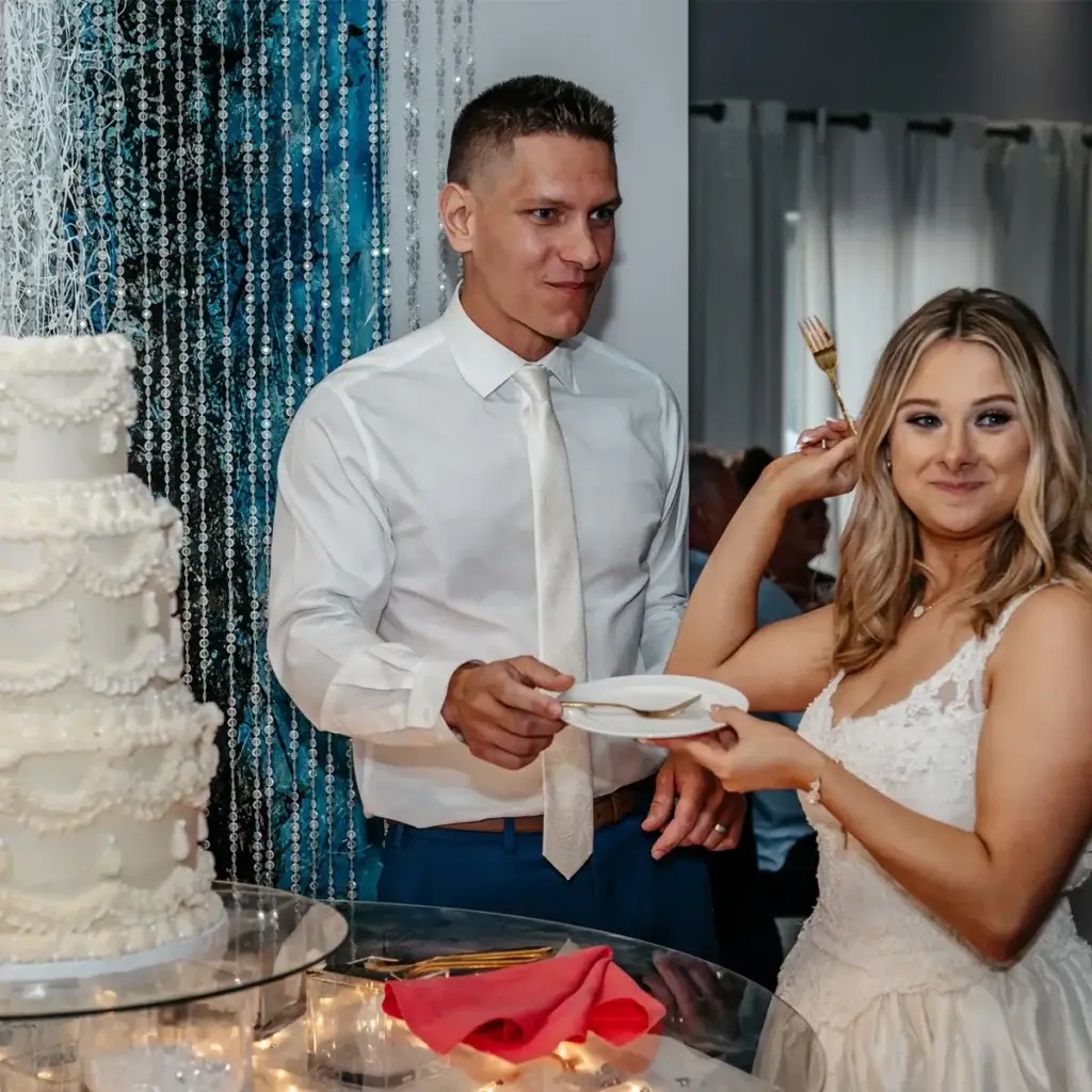 Bride and groom feeding each other cake during cake cutting at Sunset Room at The Vista wedding in Elizabeth PA