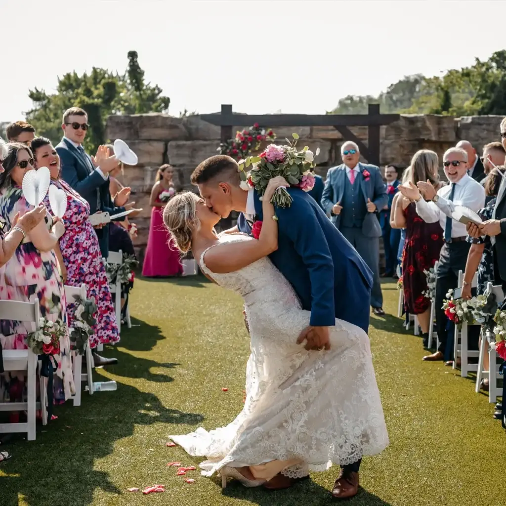 Bride and groom kissing while exiting their ceremony at Sunset Room at The Vista wedding in Elizabeth PA